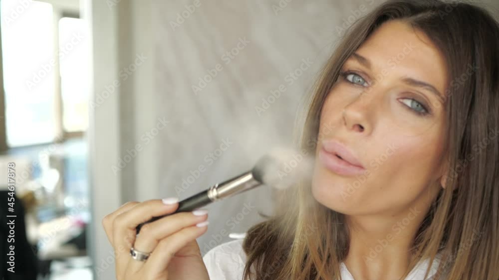 attractive girl sensually blows powder from a makeup brush directly into the camera. High quality FullHD footage attractive girl sensually blows powder from a makeup brush directly into the camera. High quality FullHD footage