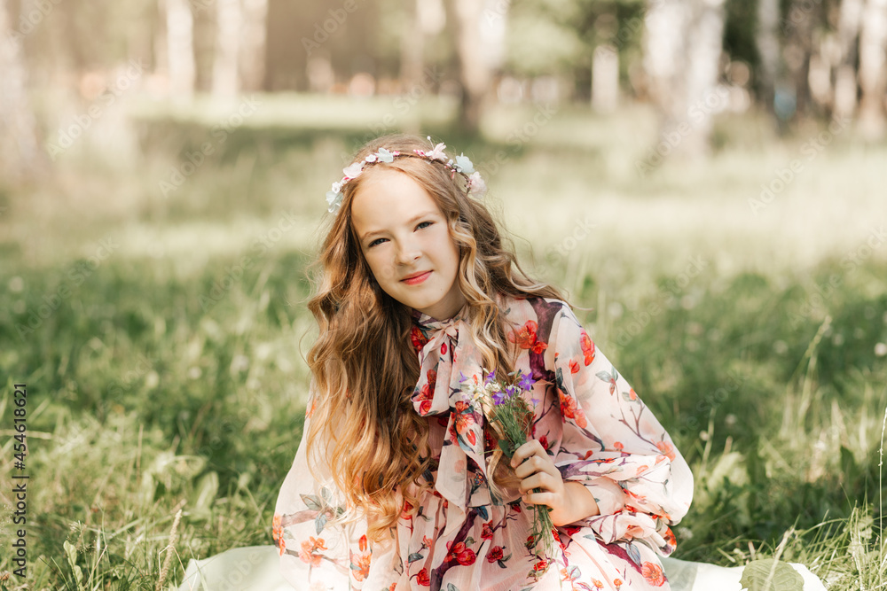 Little girl with long white hair and a bouquet of wildflowers in the park Little girl with long white hair and a bouquet of wildflowers in the park