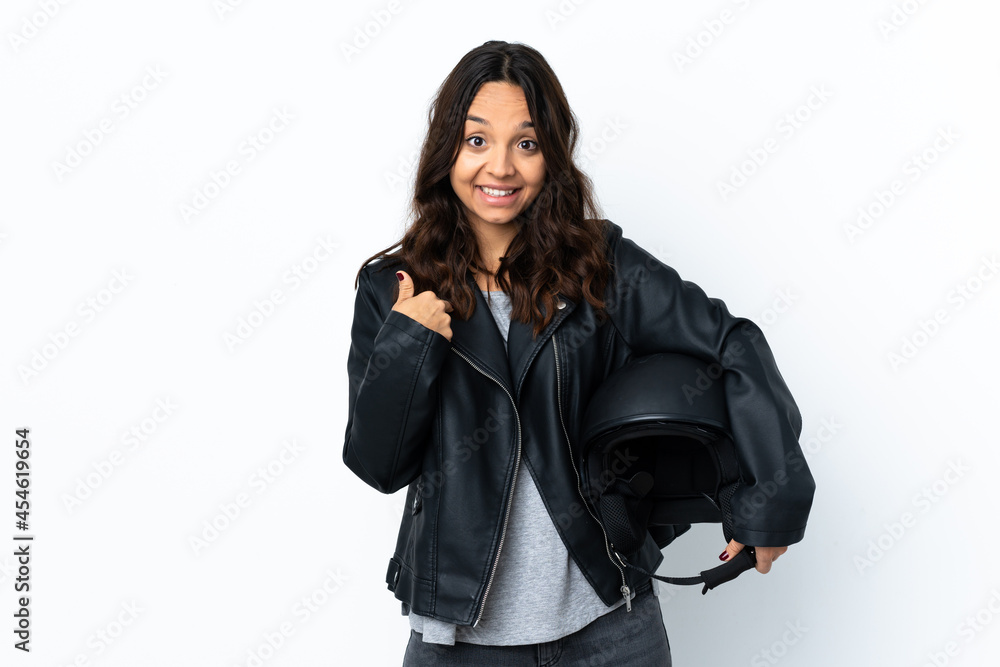 Young woman holding a motorcycle helmet over isolated white background with surprise facial expression Young woman holding a motorcycle helmet over isolated white background with surprise facial expression