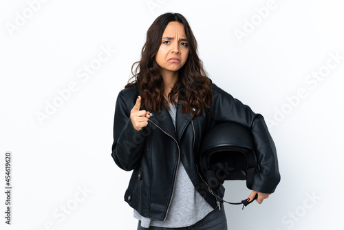 Young woman holding a motorcycle helmet over isolated white background frustrated and pointing to the front