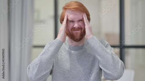 Young Beard Redhead Man having Headache