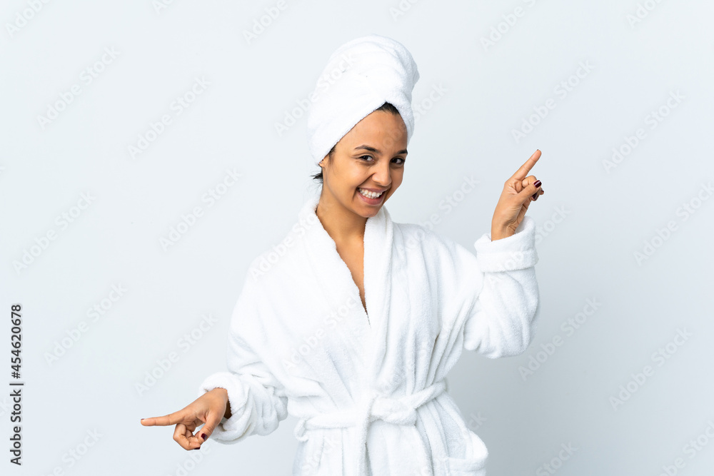 Young woman in bathrobe over isolated white background pointing finger to the laterals and happy Young woman in bathrobe over isolated white background pointing finger to the laterals and happy