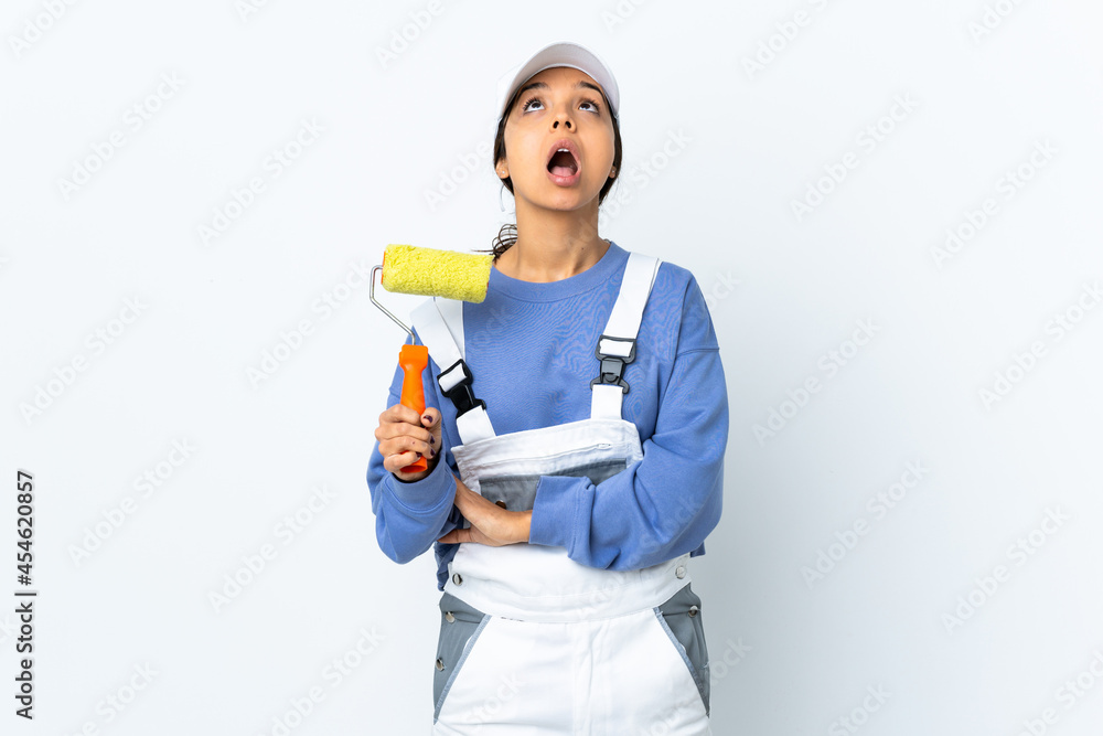 Painter woman over isolated white background looking up and with surprised expression Painter woman over isolated white background looking up and with surprised expression