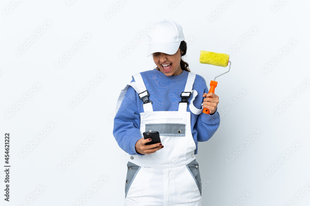Painter woman over isolated white background with phone in victory position Painter woman over isolated white background with phone in victory position