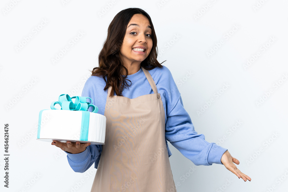 Pastry chef holding a big cake over isolated white background happy and smiling Pastry chef holding a big cake over isolated white background happy and smiling