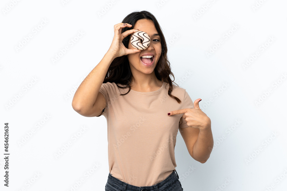 Young woman over isolated white background holding a donut and happy Young woman over isolated white background holding a donut and happy