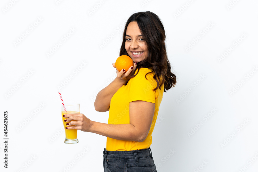 Young woman over isolated white background holding an orange and an orange juice Young woman over isolated white background holding an orange and an orange juice