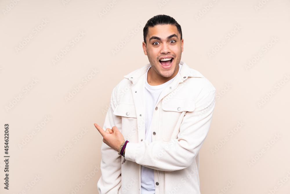 Asian handsome man over isolated background surprised and pointing side Asian handsome man over isolated background surprised and pointing side