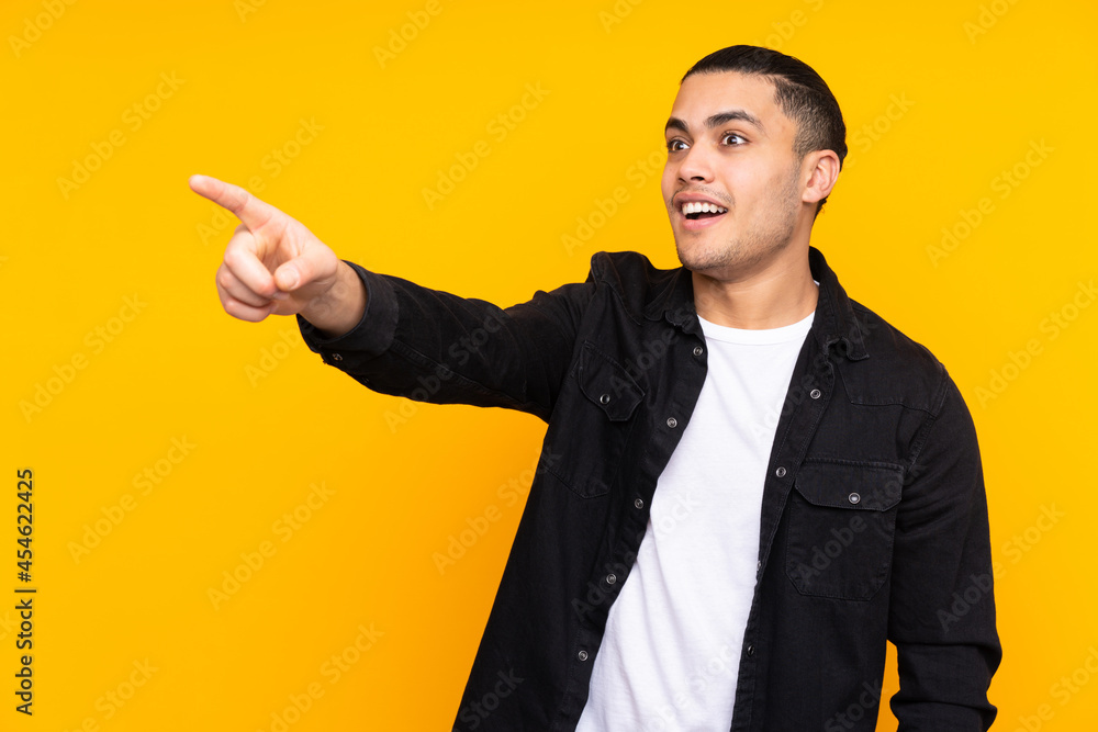 Asian handsome man isolated on yellow background frustrated and pointing to the front