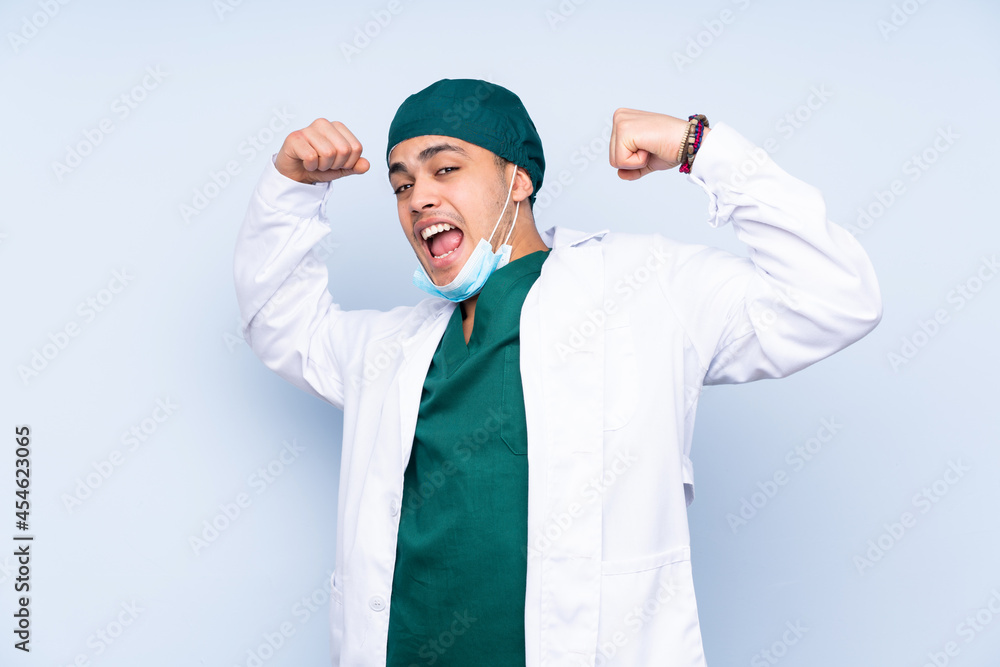 Surgeon man with uniform isolated on blue background celebrating a victory Surgeon man with uniform isolated on blue background celebrating a victory