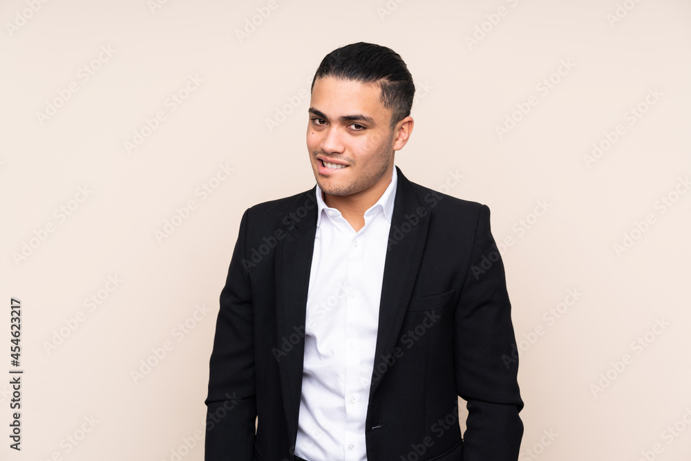 Asian business man isolated on beige background having doubts and with confuse face expression Asian business man isolated on beige background having doubts and with confuse face expression