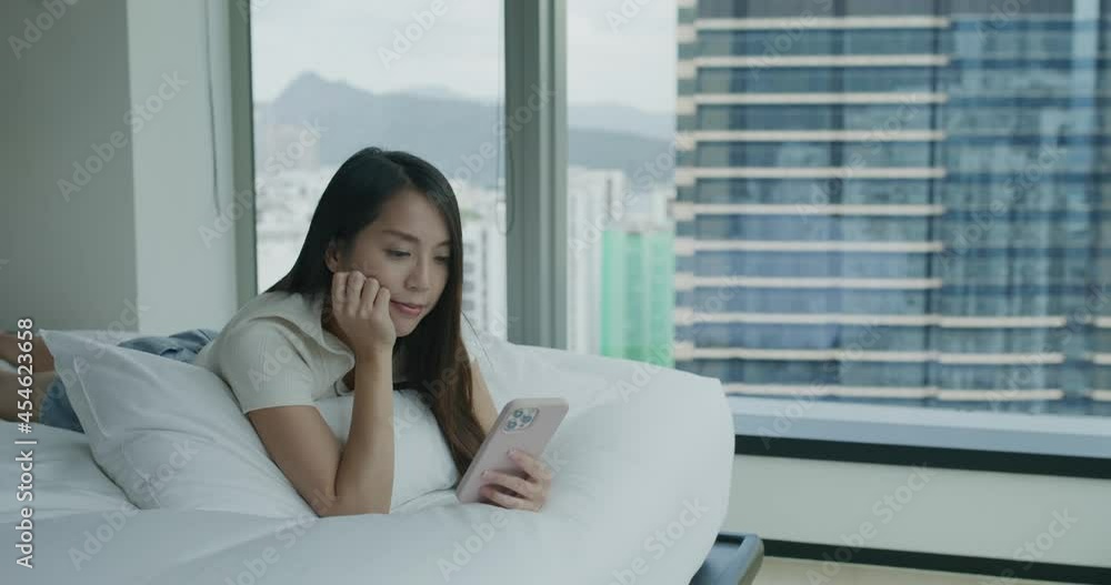 Woman use smart phone and lying on bed Woman use smart phone and lying on bed
