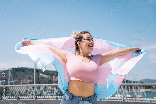 transsexual woman with trans flag, holding a transgender pride flag photo