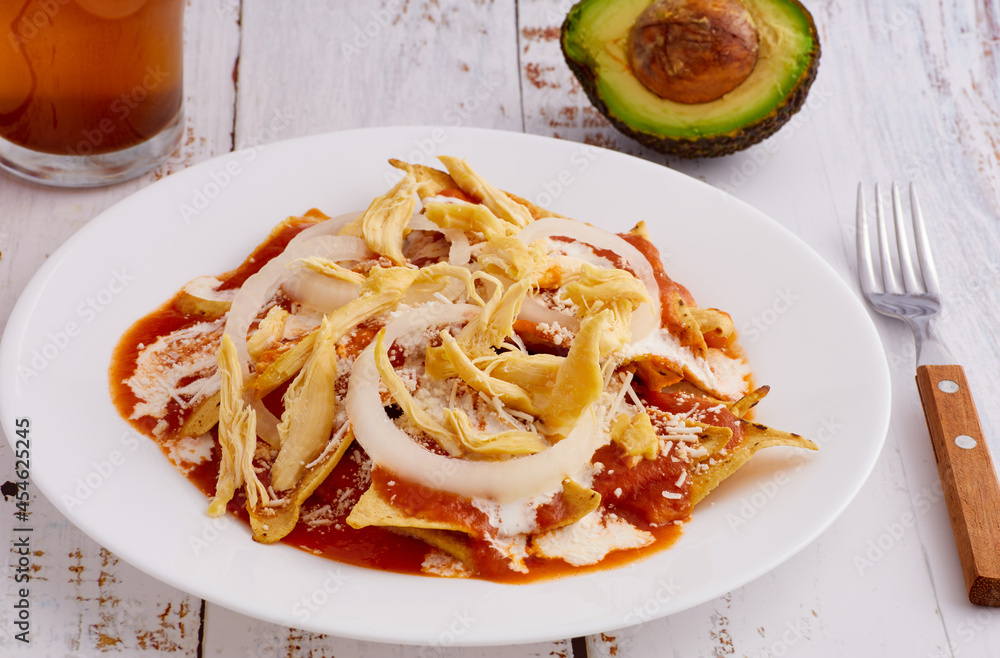 Fototapeta premium Chilaquiles rojos con pollo y aguacate comida tradicional mexicana en el desayuno o comida.