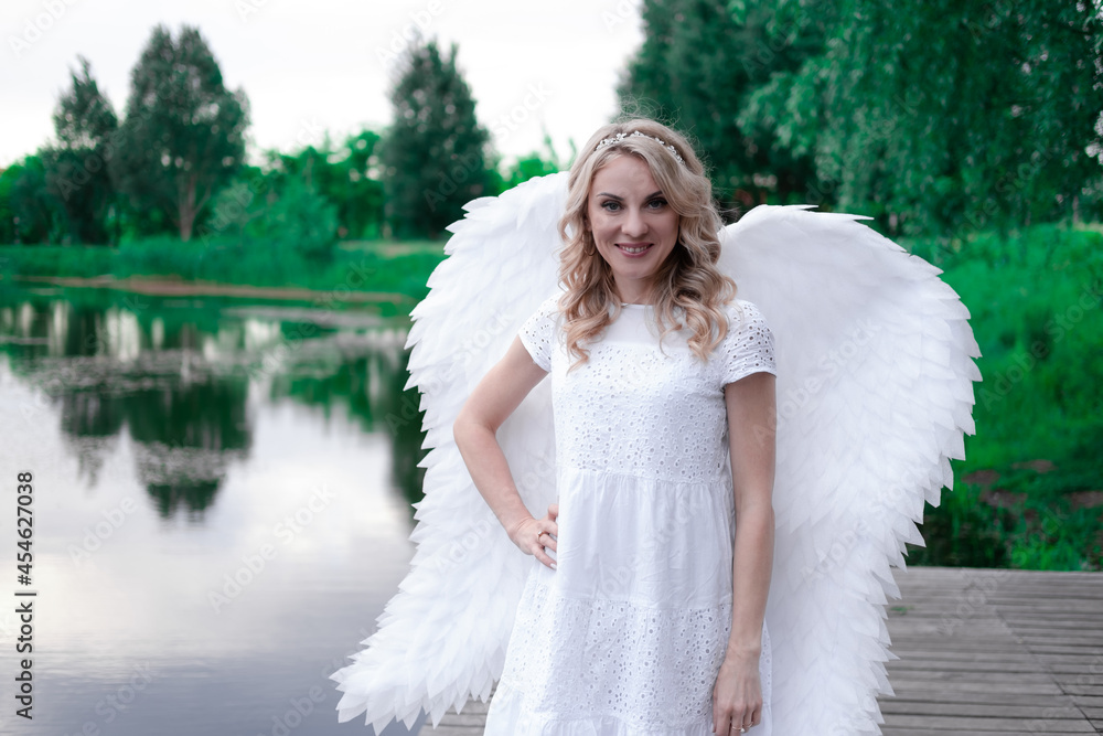 portrait of blonde woman in white dress and white angels wings. good people. heaven, god. paradise angel. portrait of blonde woman in white dress and white angels wings. good people. heaven, god. paradise angel.