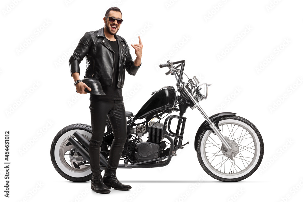 Cool biker with a chopper holding helmet and gesturing rock and roll sign Cool biker with a chopper holding helmet and gesturing rock and roll sign
