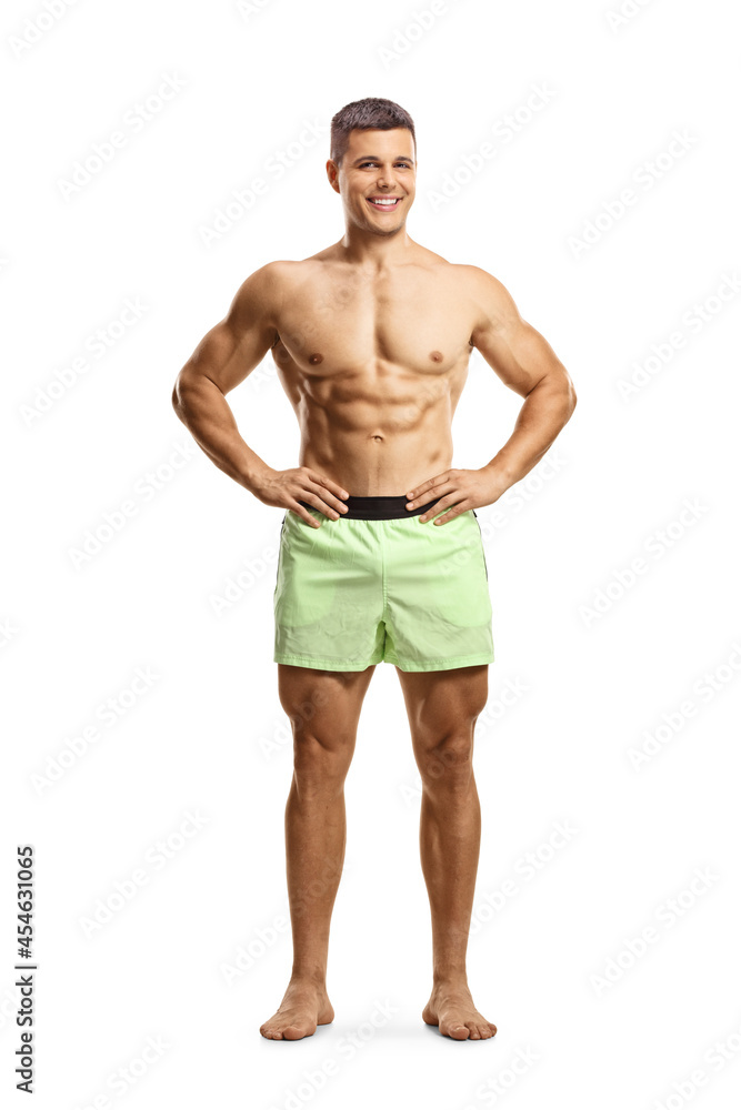 Muscular shirtless guy in swimming shorts posing and smiling