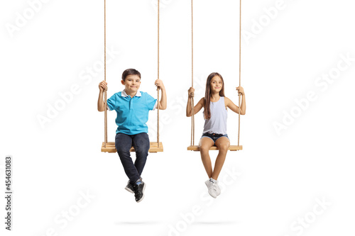 Boy and girl sitting on swings and looking at camera