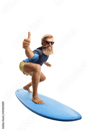 Fotografia Bearded young man surfing and showing thumbs up