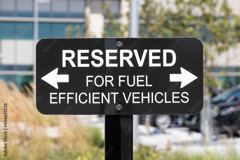 RESERVED For Fuel Efficient vehicles sign. Parking is reserved for electric, EV and hybrid electric vehicles in an effort to promote green and clean driving. RESERVED For Fuel Efficient vehicles sign. Parking is reserved for electric, EV and hybrid electric vehicles in an effort to promote green and clean driving.