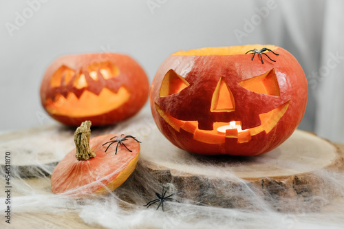 Halloween curved pumpkins on the decorated table with spider web. Light for the holoday at home photo