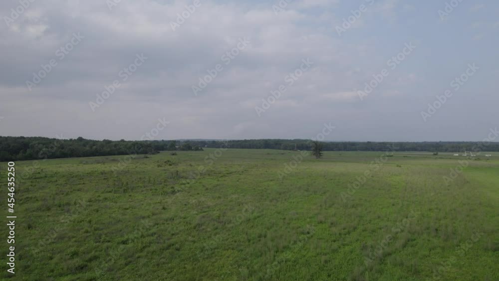Drone flying over large open green field Drone flying over large open green field