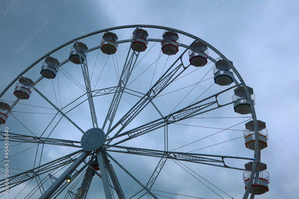 Ferris wheel spinning in an amusement park. Fairground ride. Cabins of the ferris wheel. Ferris wheel spinning in an amusement park. Fairground ride. Cabins of the ferris wheel.