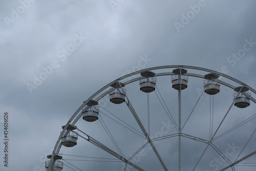 Ferris wheel spinning in an amusement park. Fairground ride.  Cabins of the ferris wheel. 