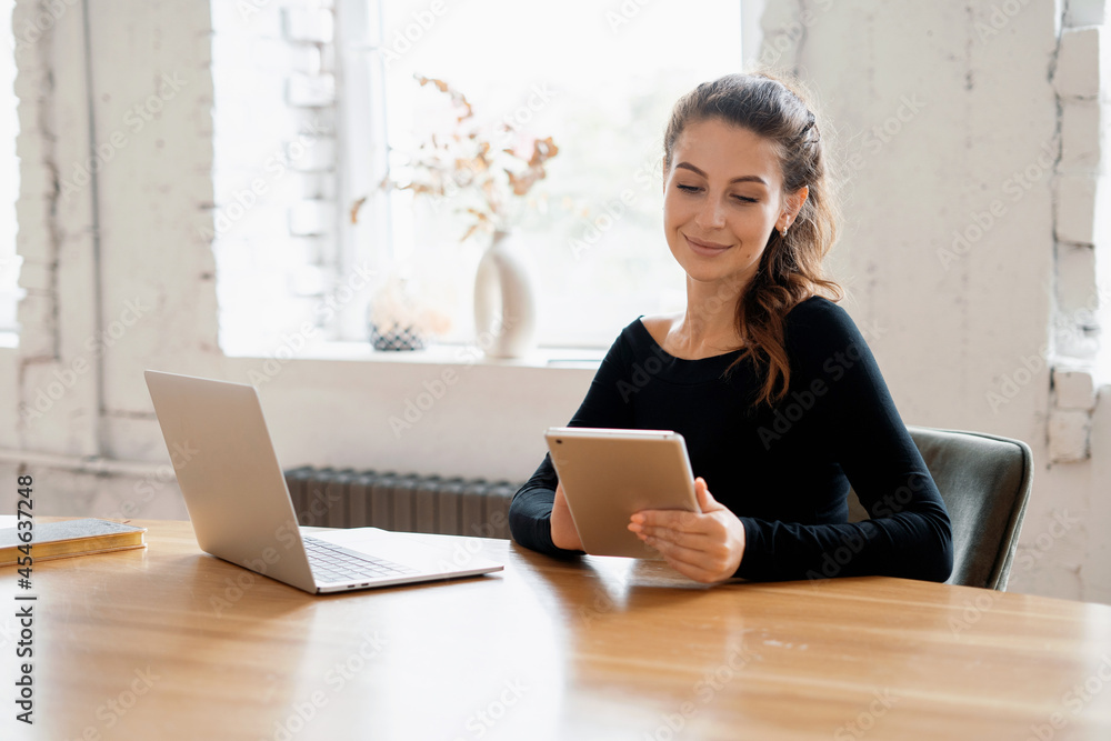 Female student online training. A freelancer works on a tablet in a coworking space. The blogger writes down the plans in notes. Ordering a shopping product on the store's website. Female student online training. A freelancer works on a tablet in a coworking space. The blogger writes down the plans in notes. Ordering a shopping product on the store's website.