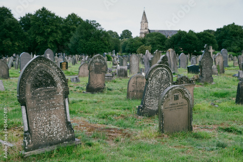 Bild auf Leinwand A view of an old christian cemetery with chrurch on the background - spooky, Hal