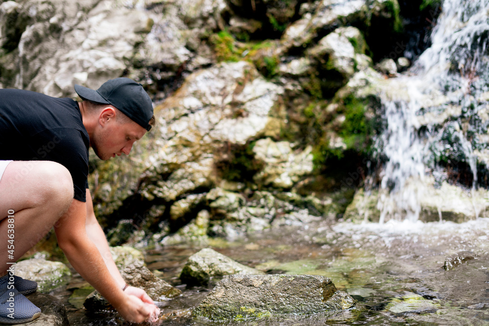 man drinking pure water from mountain river man drinking pure water from mountain river