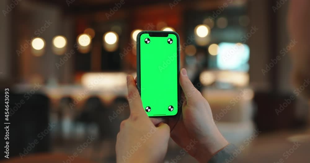 Close up shot of usage of smartphone with green mock up display. Person surfing web, watching video or having an online chat in cafe - always online, technology concept 4k footage Close up shot of usage of smartphone with green mock up display. Person surfing web, watching video or having an online chat in cafe - always online, technology concept 4k footage