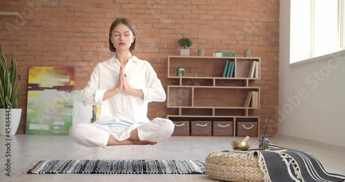 Levitating young woman practicing yoga at home photo