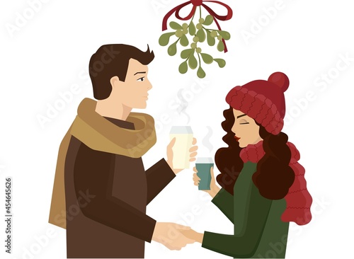 A couple stands under the mistletoe. The guy holds the girl's hand and is going to kiss her. They have a date. It's winter outside and they are drinking hot coffee.