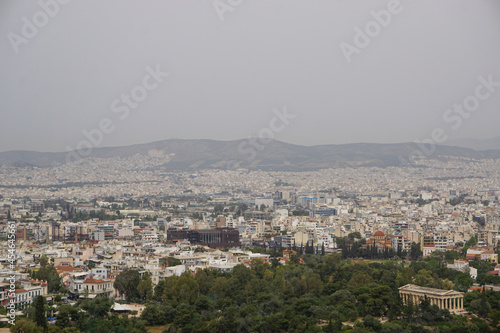 Athens, Greece: View from the Acropolis of the Doric Temple of Hephaestus and the Athens skyline, under a hazy sky caused by dust pollution.