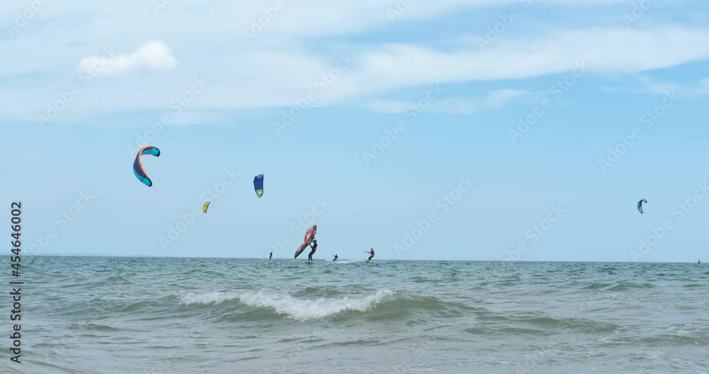 Kitesurfing in summer. A view of surfing kitesurfing on sea surface and in the sky during summer vacation. Kitesurfing in summer. A view of surfing kitesurfing on sea surface and in the sky during summer vacation.