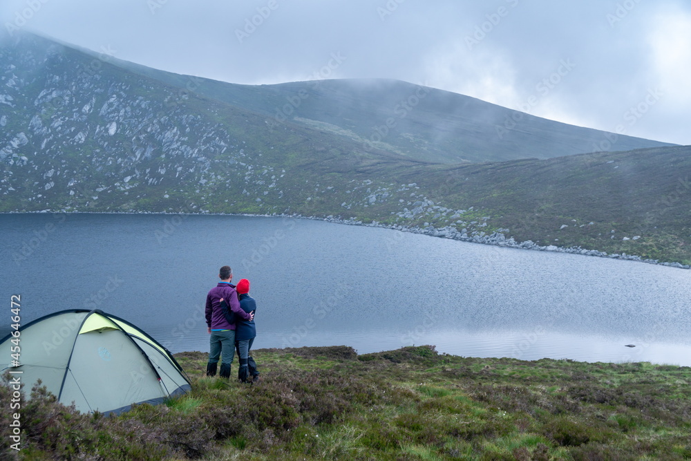 Lake landscape. Tourists camping tent.. Young charming couple in love playing .Relaxing with nature,lifestyle concept.