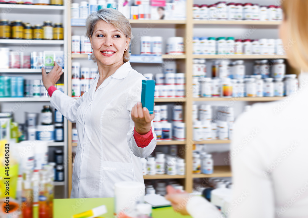 Laughing woman recommending care products to customer in specialized shop