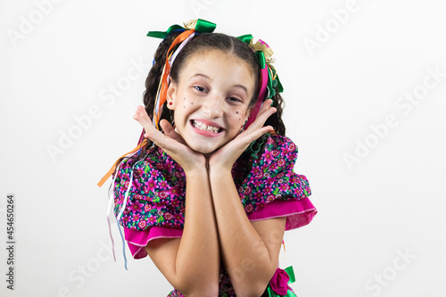 Brazilian little girl dressed for June party, carnival, são João , happy and excited in studio with white background.