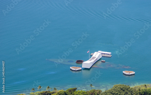 Aerial view of the USS Arizona memorial in Pearl Harbor, Hawaii. USS Arizona is visible underwater. Ample copy space in blue water.