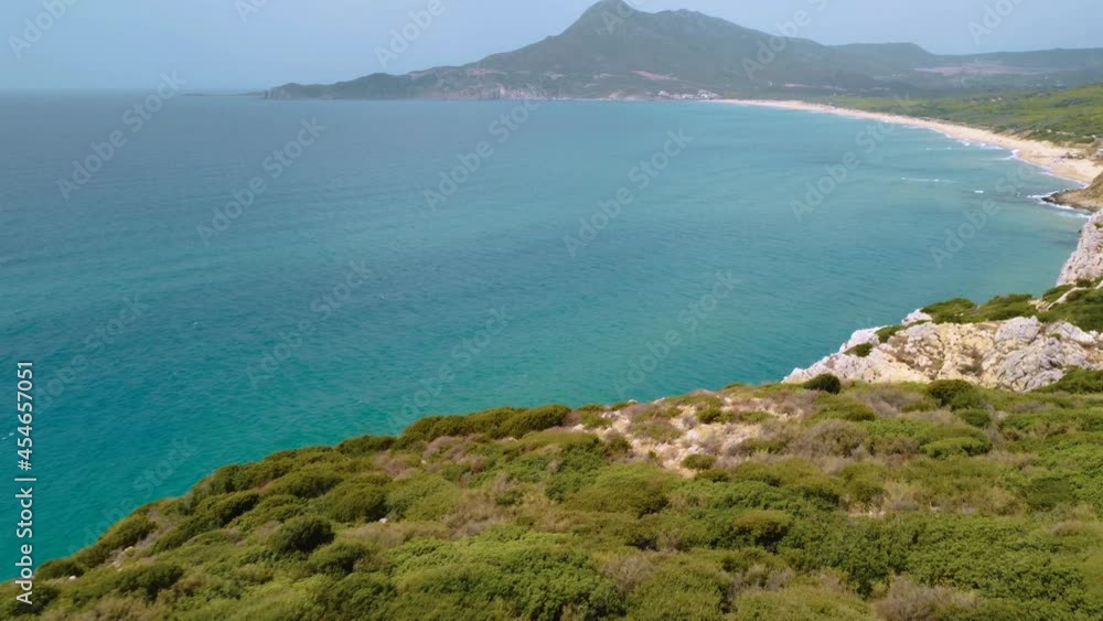 Natural rocky coast beach sandy bay on the tourist vacation island Sardinia, Italy, with mountains and sun, clear blue turquoise and calm water close to Costa Rei. Aerial Drone air view flight Natural rocky coast beach sandy bay on the tourist vacation island Sardinia, Italy, with mountains and sun, clear blue turquoise and calm water close to Costa Rei. Aerial Drone air view flight