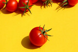 Red ripe tomato lies on a yellow background