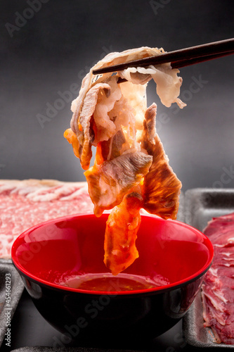 Foto Chopsticks are picking up cooked meat and dipping in the dipping sauce