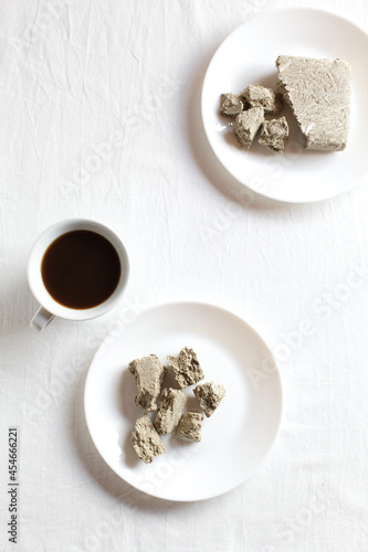 Cup of natural coffee. Halva dessert in plates on a white background. Copy of space, top view