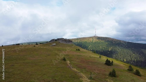 Drone closing in to Petrovy kameny (Peters Rocks) and Praděd mountain over grass land in Jeseniky Mountains - Czech republic. photo