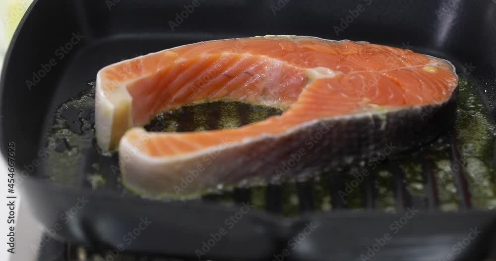 Big piece of fresh fish on hot metal pan for making fish steak. Big piece of fresh fish on hot metal pan for making fish steak.