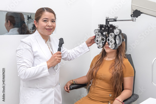 Young woman affected eyes by computer screens and phones. The ophthalmologist smiles after reviewing the patient