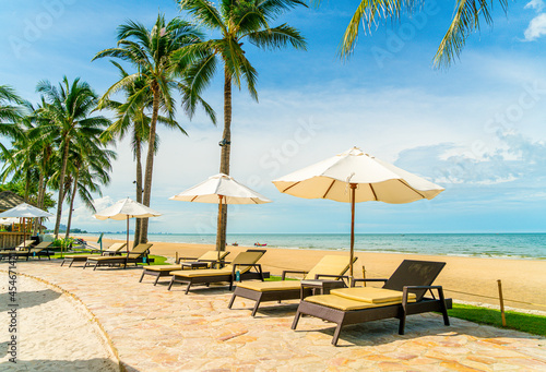 Fototapeta Naklejka Na Ścianę i Meble -  Beautiful tropical beach and sea with umbrella and chair around swimming pool in hotel resort