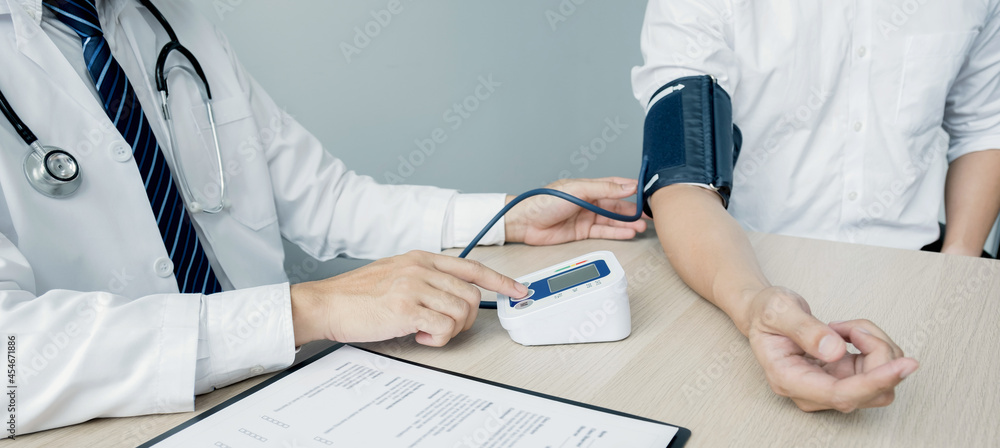 The man doctor hand use the pulse meter to measure the pressure of the patient, medical checkup concept The man doctor hand use the pulse meter to measure the pressure of the patient, medical checkup concept