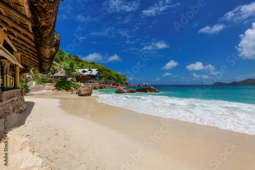 Tropical resort with outdoor restaurant at the tropical beach with ocean wave